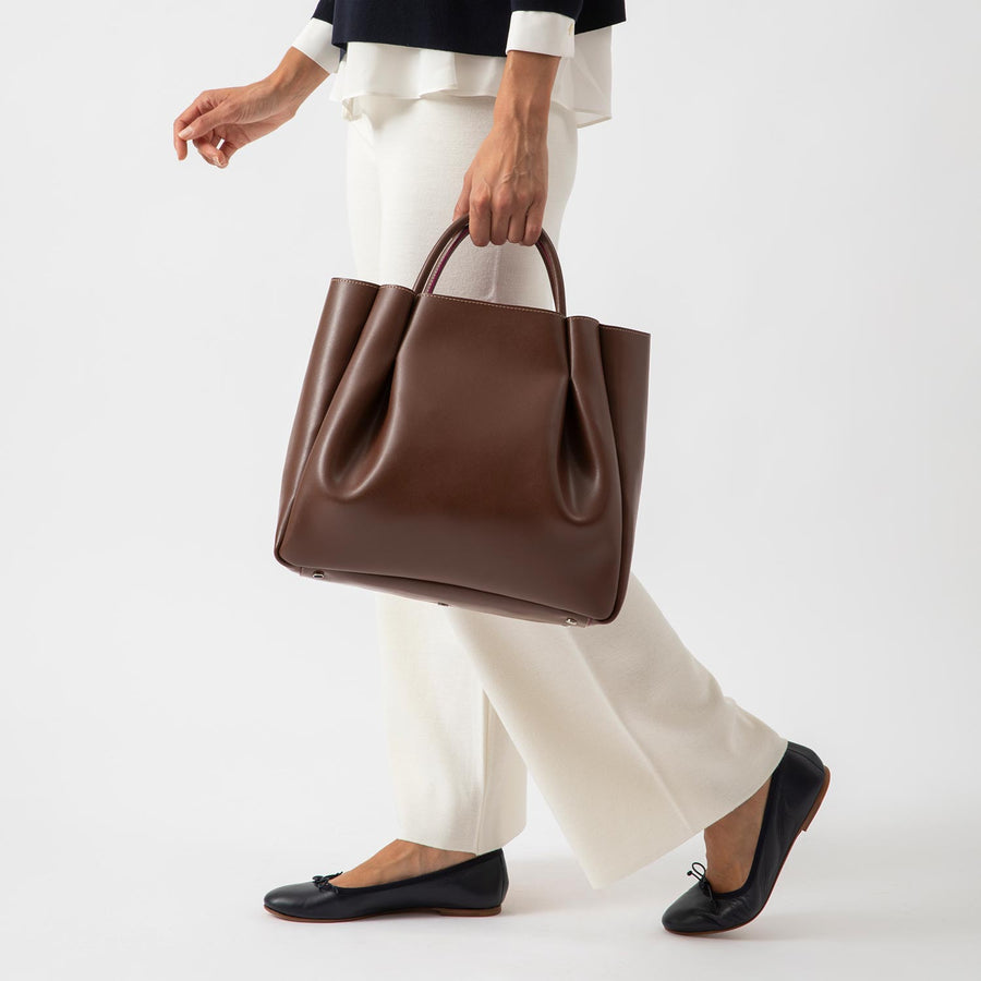 woman wearing large chocolate brown leather tote bag purse