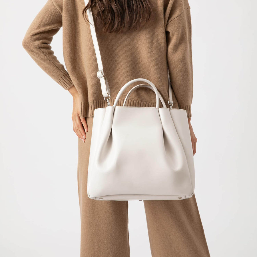 woman wearing large cream white leather tote bag purse