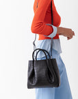 woman wearing medium black leather croc print tote bag purse with shoulder strap