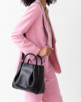 woman wearing medium black leather tote bag purse with shoulder strap