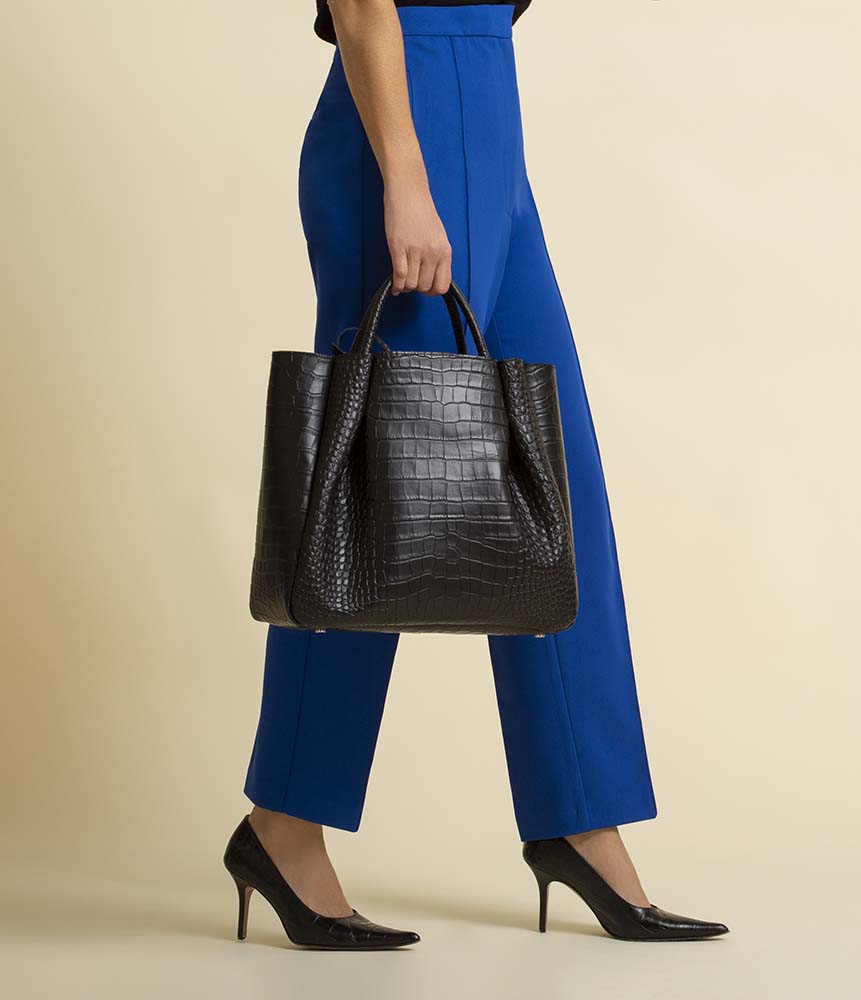 woman holding large black leather tote bag purse