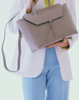 woman wearing large light brown leather work tote bag purse with shoulder strap